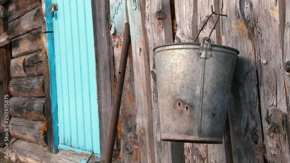 rusty bucket on the wooden wall of an old barn rusty bucket on the wooden wall of an old barn