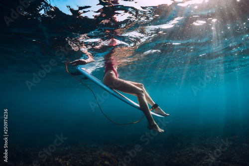 Photography Young surf girl at surfboard underwater in ocean