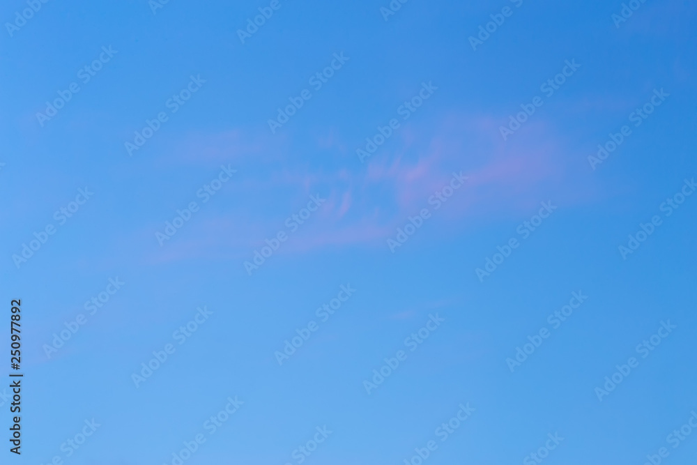 Background of sky with thin pink cloud at the golden hour.