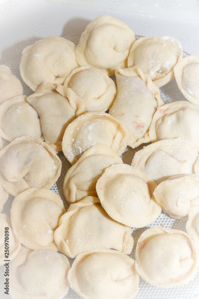 Raw and fresh dumplings lie on a glass plate Raw and fresh dumplings lie on a glass plate