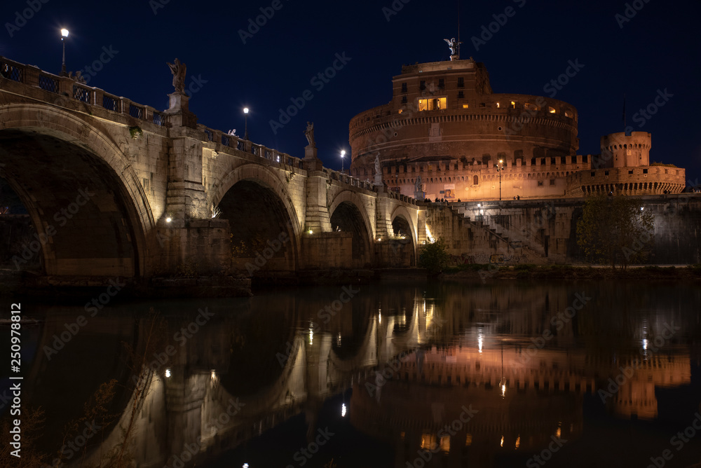 Obraz premium beautiful view of Castel Sant'Angelo and the bridge at night with reflections on the Tiber river. Rome Italy
