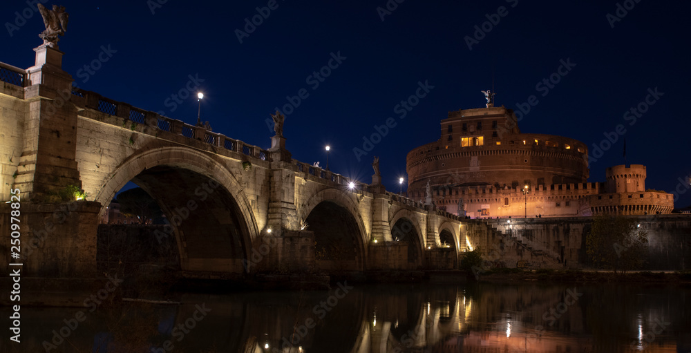 beautiful view of Castel Sant'Angelo and the bridge at night with reflections on the Tiber river. Rome Italy
