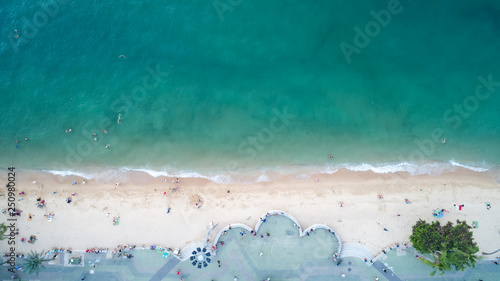 Beautiful natural aerial view of Pattaya Beach with turquoise seawater and white fluffy bubble from wave which is rolling to white sand beach. © Pornprasert