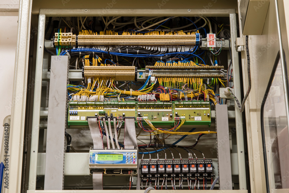 Uncovered switchboard with wires.