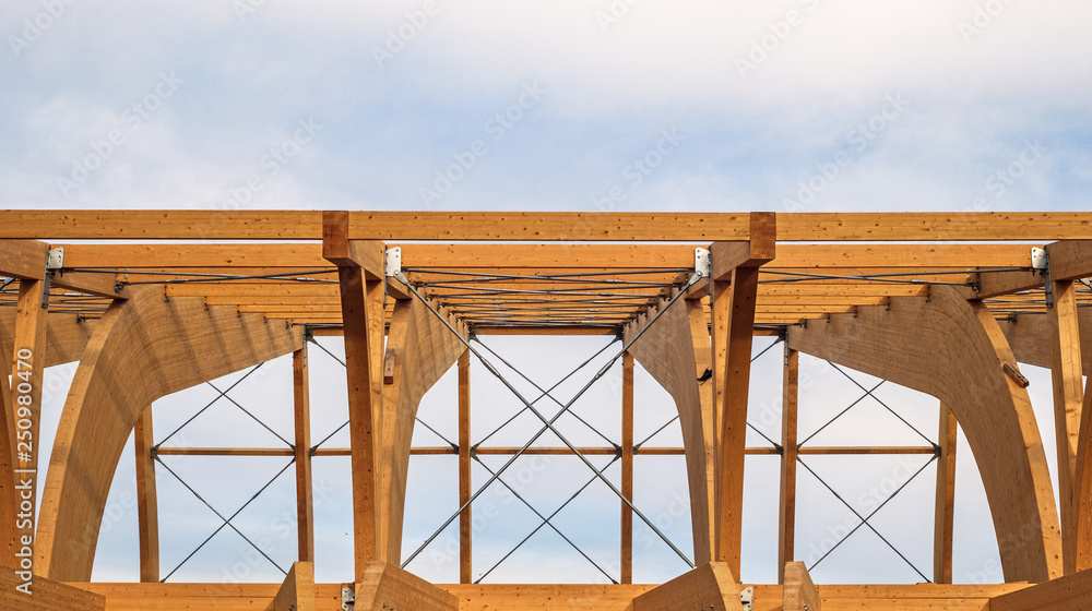 Obraz premium Szczegół nowożytna drewniana architektura w kleiącym laminującym drewnie na błękitnym chmurnym niebie