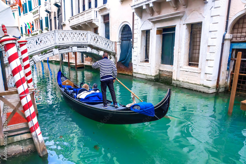 Venetian gondolier gondola through of Venice. Italy