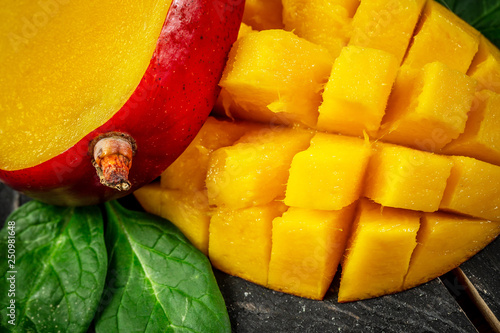 Close-up Mango fruit and mango cubes on a wooden background, top view