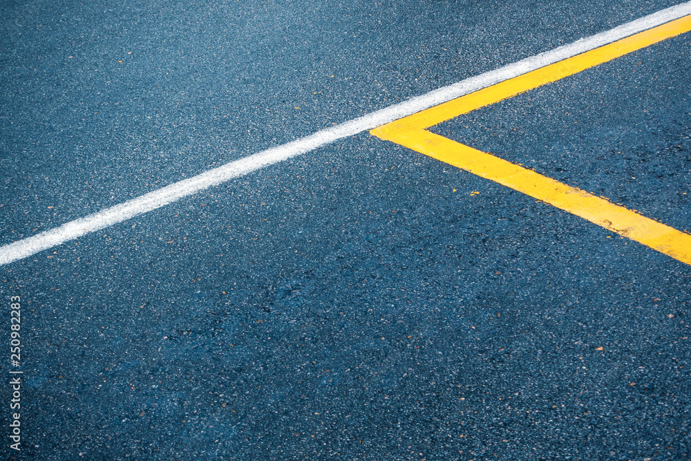 Asphalt road surface with white and yellow lines