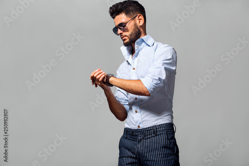 Elegant young handsome man in suite wearing glasses. Studio fashion portrait.