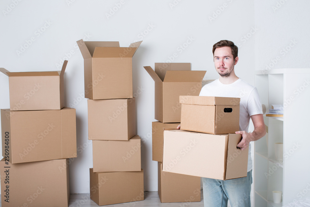 Young man with carton boxes in new apartment. Young man with carton boxes in new apartment.
