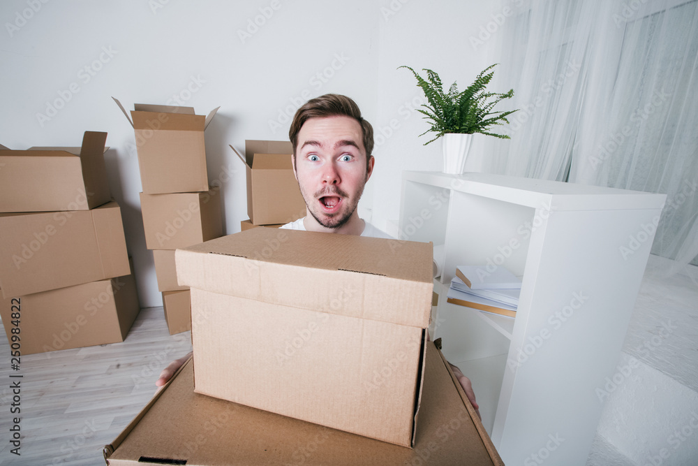 Young man with carton boxes in new apartment. Young man with carton boxes in new apartment.