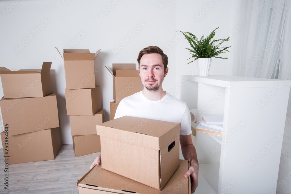 Young man with carton boxes in new apartment. Young man with carton boxes in new apartment.