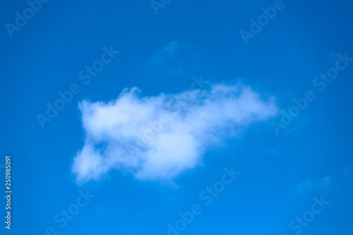 Blue sky background with white clouds. On the blue sky in the center is a white cloud. Abstract  cropped shot  horizontal  free space.