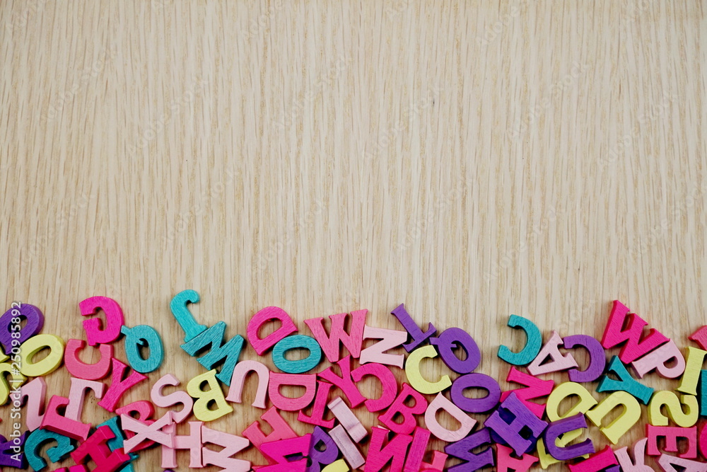 random colorful letterpress alphabet with space copy top view on wooden background