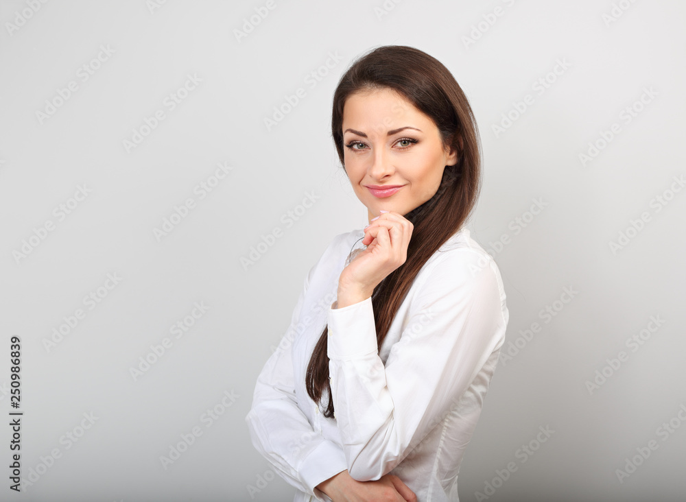Beautiful business calm confident woman in white looking with hand under the face Beautiful business calm confident woman in white looking with hand under the face