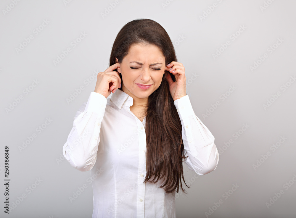 Stressed unhappy business woman with head pain closed ears the hands because not want the hear any sounds Stressed unhappy business woman with head pain closed ears the hands because not want the hear any sounds