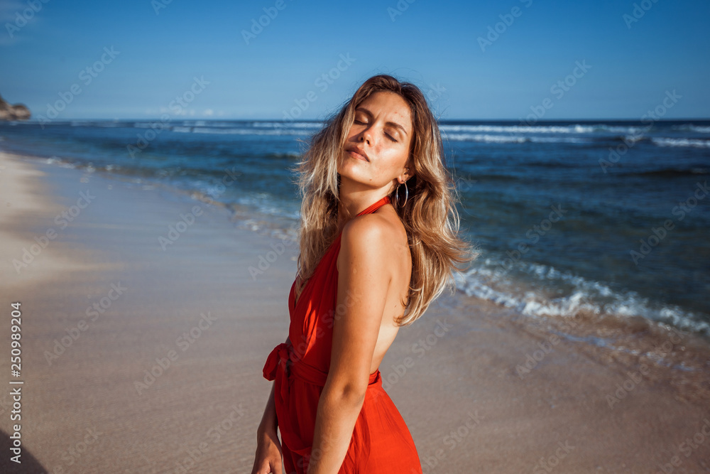 Portrait of a sexy girl on the Beach in a red dress Portrait of a sexy girl on the Beach in a red dress