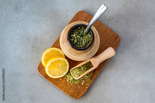 Traditional Yerba Mate tea with matero and bombilla, healthy, energy boosting beverage drink on neutral stone gray background.