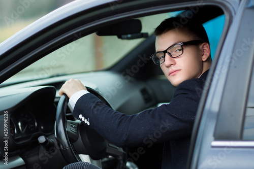 close up.successful young businessman sitting behind the wheel of a car.