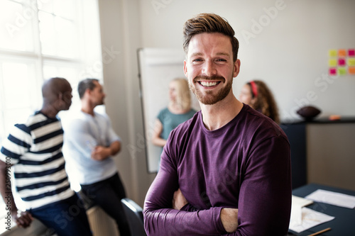 Smiling young designer standing in an office after a presentatio