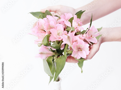 bouquet of flowers in female hands isolated on a light backgrou