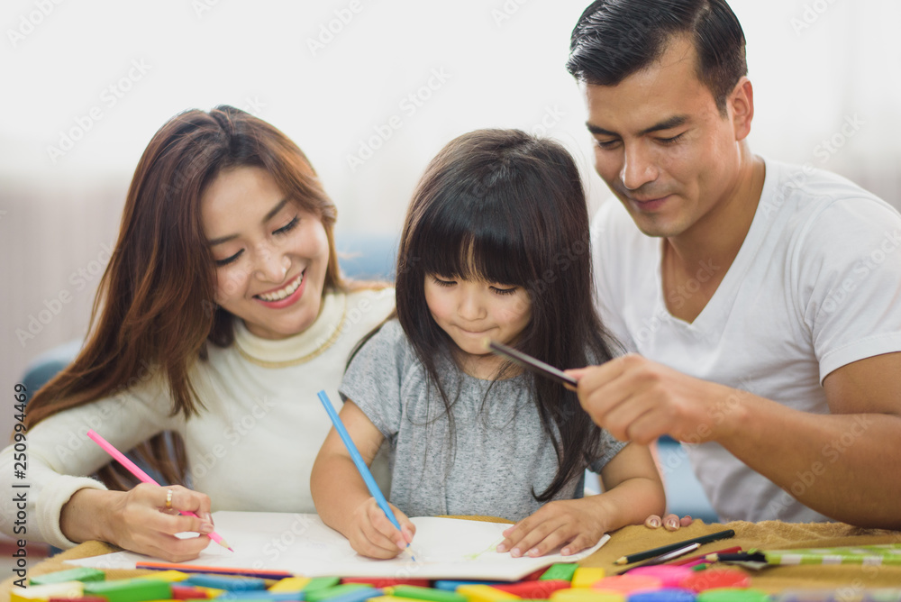 Fototapeta premium Family time Daughter laughing enjoying playing with her parent on the table in front of sofa at home.