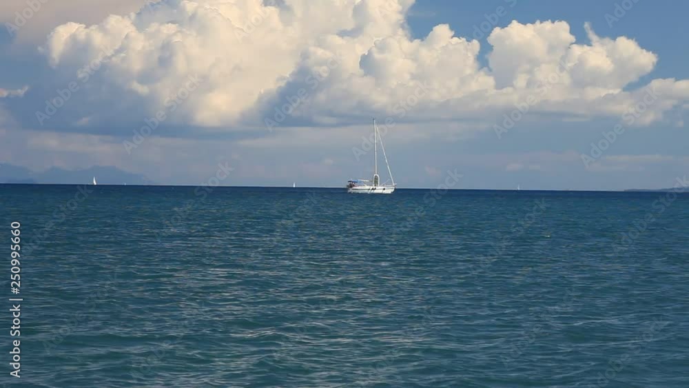 Beautiful view as the yacht floats in the sea and white clouds in the sky on Corfu island Beautiful view as the yacht floats in the sea and white clouds in the sky on Corfu island