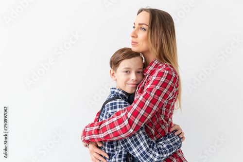 Family, fashion and mothers day concept - Portrait of mother and son dressed in plaid shirts on white background with copy space