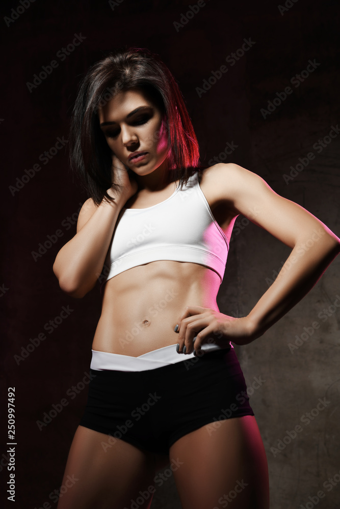 Fototapeta premium Fitness and diet concept close up of female abdominal muscles on dark background