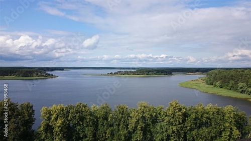 Blue sky and blue lake in summer. White clouds are reflected in the water. The famous lake Seliger. Russia.