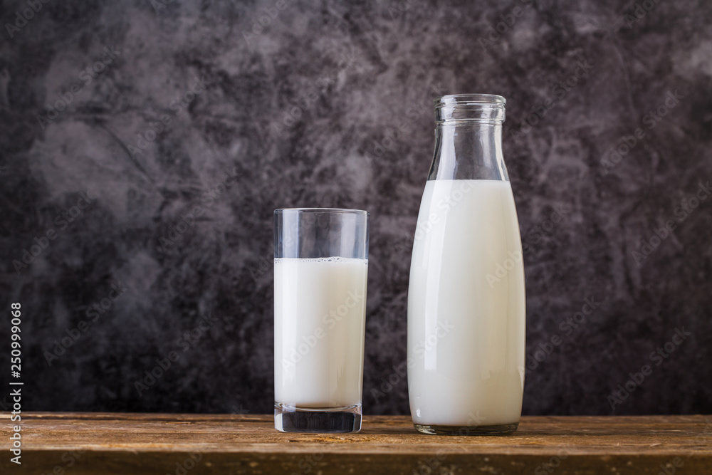 Glass and Bottle of fresh milk. Bottle with milk and glass of milk on wooden table. Glass and Bottle of fresh milk. Bottle with milk and glass of milk on wooden table.