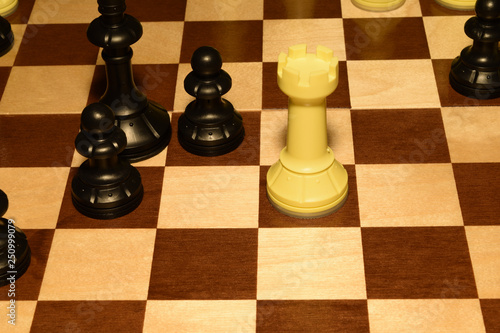 Wooden chessboard with black pieces as a game theme