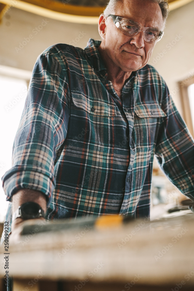 Senior carpenter with protective eye wear Senior carpenter with protective eye wear