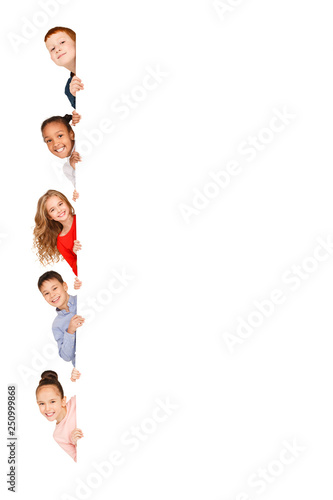 Children peeking out from empty board isolated on white photo