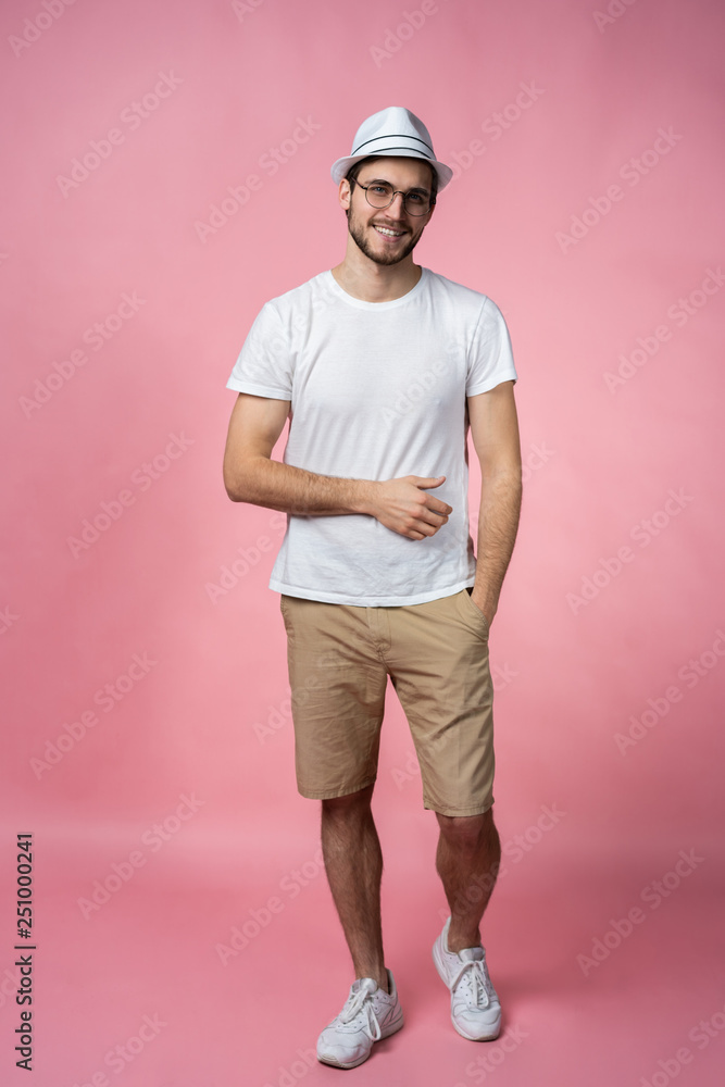 Cheerful hipster guy smiles happily, has excited expression, dresssed casually isolated over pink studio background. People, youth, emotions concept. Cheerful hipster guy smiles happily, has excited expression, dresssed casually isolated over pink studio background. People, youth, emotions concept.
