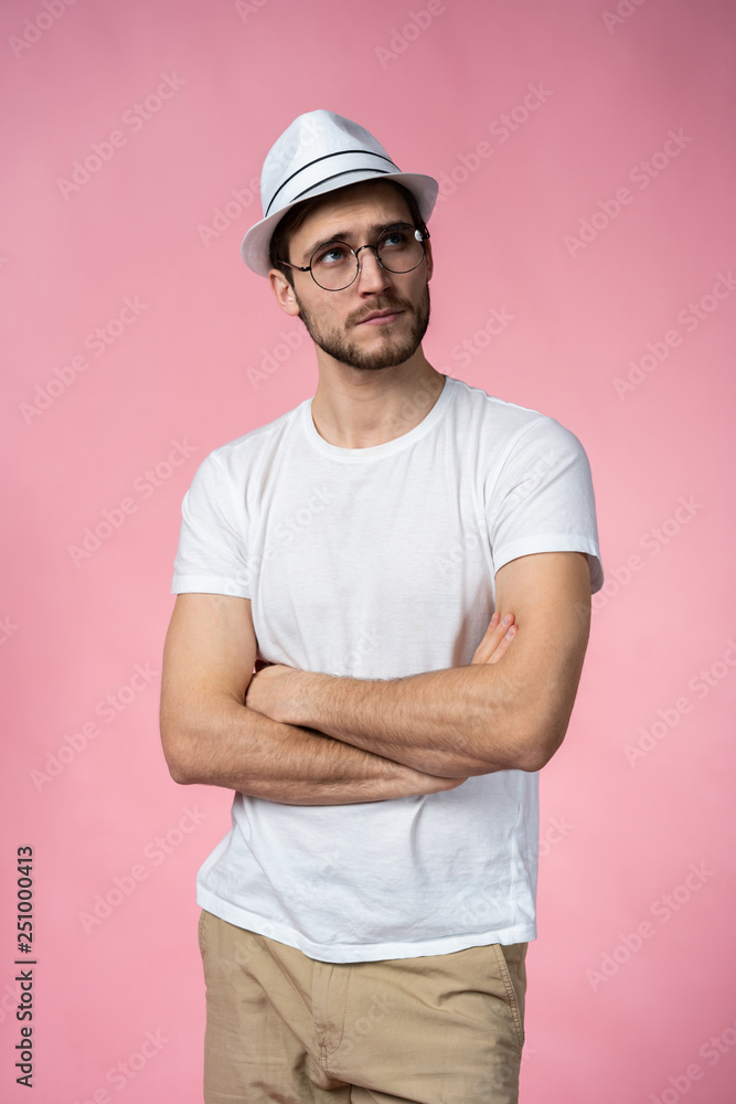 Portrait of the young thinking man looks up - isolated on pink Portrait of the young thinking man looks up - isolated on pink