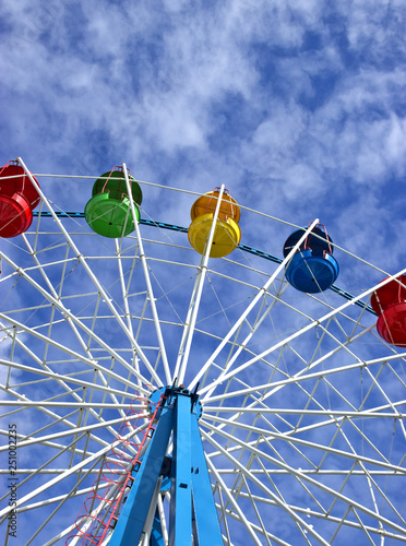 Ferris wheel against blue cloudy sky