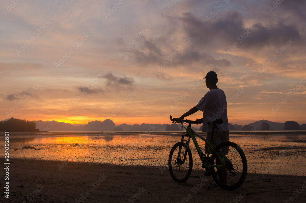 Fototapeta premium Silhouette of a man and bicycle on beach