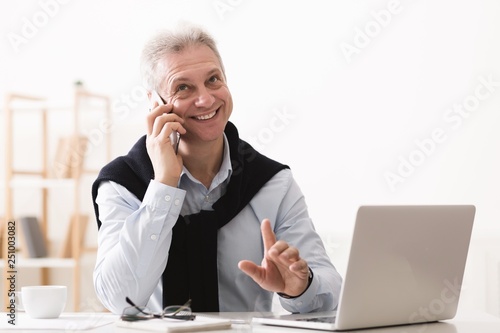 Executive senior businessman consulting clients, working on laptop