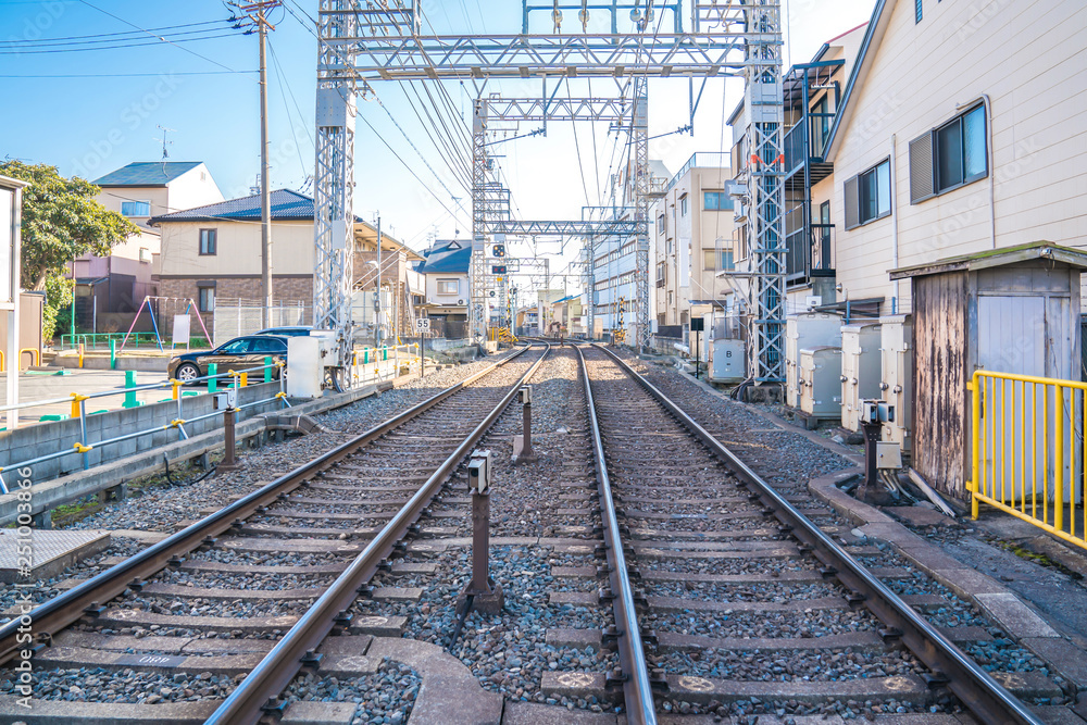 local japanese railroad tracks with home and car parking beside