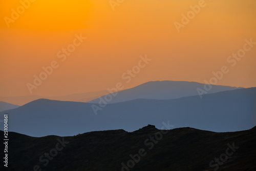 mountain ridge silhouette in a mist at the twilight © Yuriy Kulik