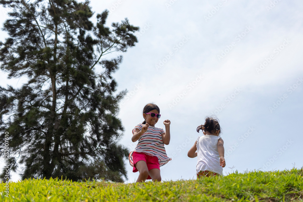 Cheerful girls, playing together in the park