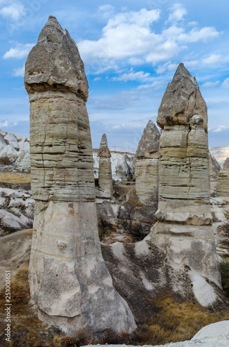 The volcanic landscape of valley with natural rock formations known as fairy chimneys, located near Goreme town, Cappadocia region of Turkey