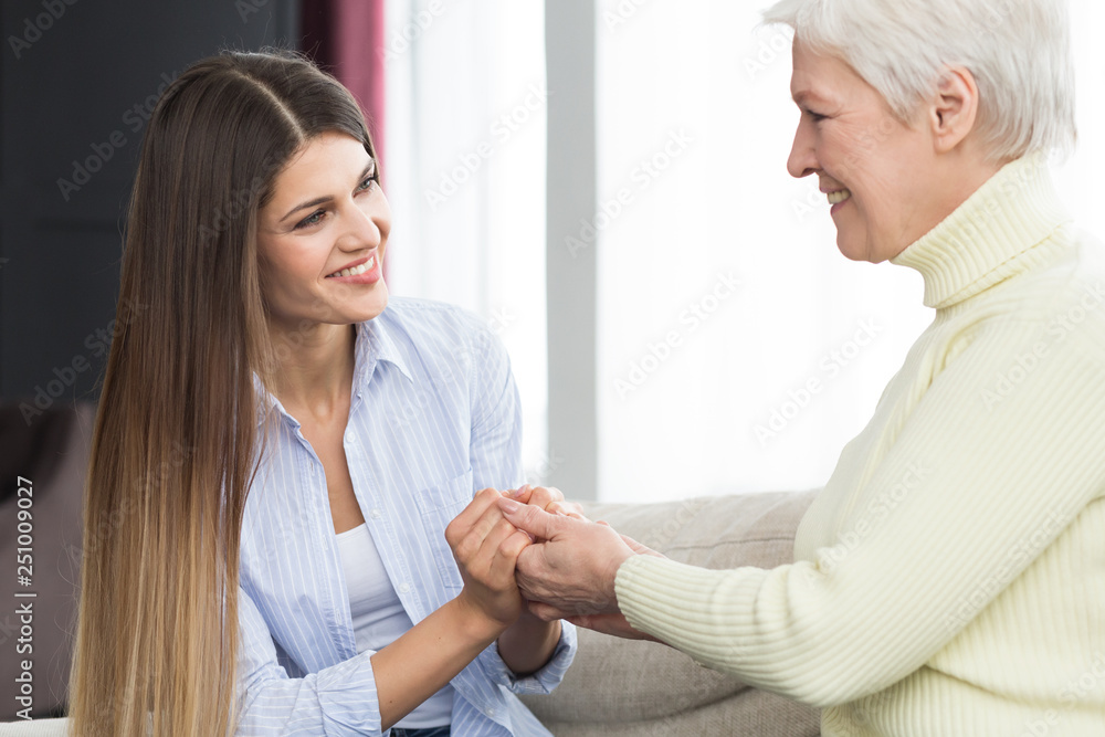 Fototapeta premium Family support. Daughter holding mother hands and talking