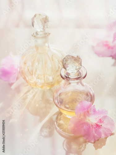 Spa still life with perfume and aromatic oils bottles surrounded by flowers