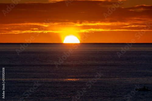 Scenic colorful sunrise over dark blue ocean water