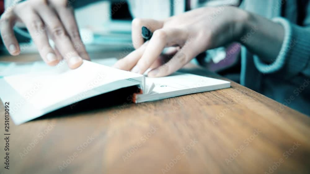 Woman preparing to fill a banking cheque check writingwith luxury fountain pen the requested data in the luxury first class checkbook Woman preparing to fill a banking cheque check writingwith luxury fountain pen the requested data in the luxury first class checkbook