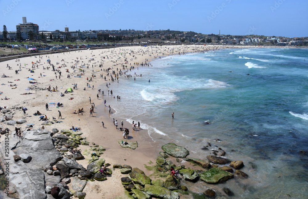 People relaxing at the beach on a hot sunday in Spring time. Bondi beach, Sydney, NSW, Australia.