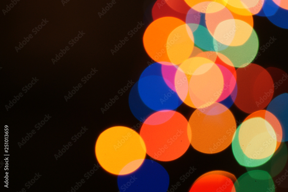 Multi-color holiday garland. Garland is blurred. Many colorful round lights. Fully defocused photo. Blurred background and foreground. Holiday mood. New Year and Christmas is coming. Multi-color holiday garland. Garland is blurred. Many colorful round lights. Fully defocused photo. Blurred background and foreground. Holiday mood. New Year and Christmas is coming.