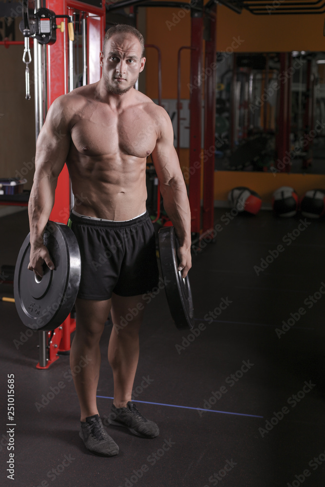 a man is engaged in bodybuilding in the gym, raises the bar and trains his muscles. a man is engaged in bodybuilding in the gym, raises the bar and trains his muscles.